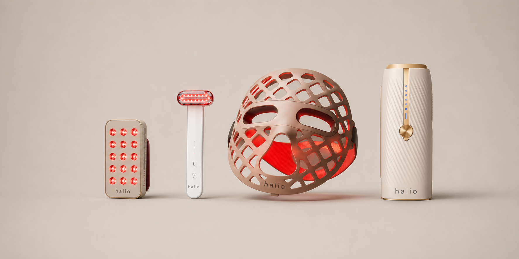 Flat lay of premium at-home beauty devices including LED face mask, red light wand, microcurrent device, and IPL hair removal device on neutral background