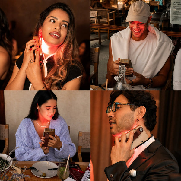 Four people use the Halio RegenBoost handheld red light panel on their faces and necks in a restaurant setting.