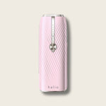 Halio pink InfinityGlow IPL hair removal device with metallic control strip and circular button.