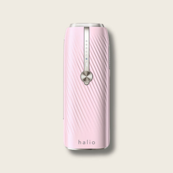 Halio pink InfinityGlow IPL hair removal device with metallic control strip and circular button.