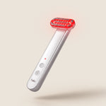 Halio handheld red light therapy wand with glowing red LED head and white handle, shown floating against a beige background