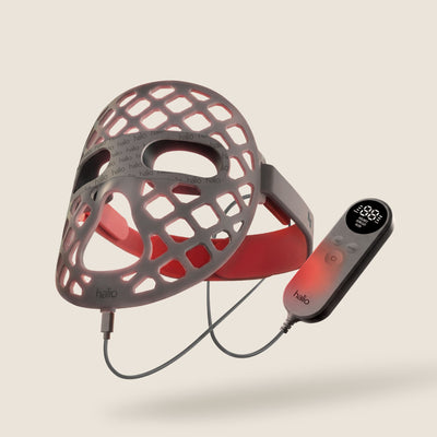 Halio red light therapy helmet with honeycomb LED openings and wired handheld controller.