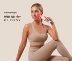 Woman using a white facial device with red lights; banner reads “In the spotlight Vanity Fair Glossy.”