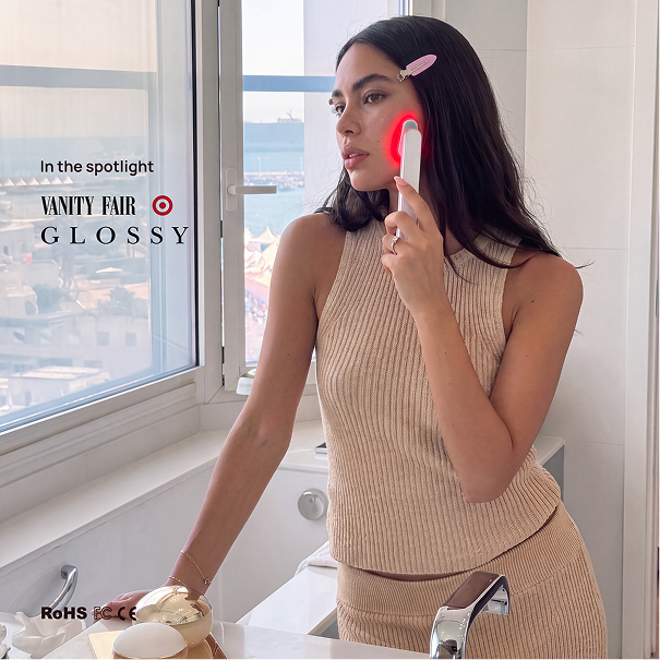 Woman using a Halio red light therapy wand on her cheek, with “In the spotlight VANITY FAIR GLOSSY” text.